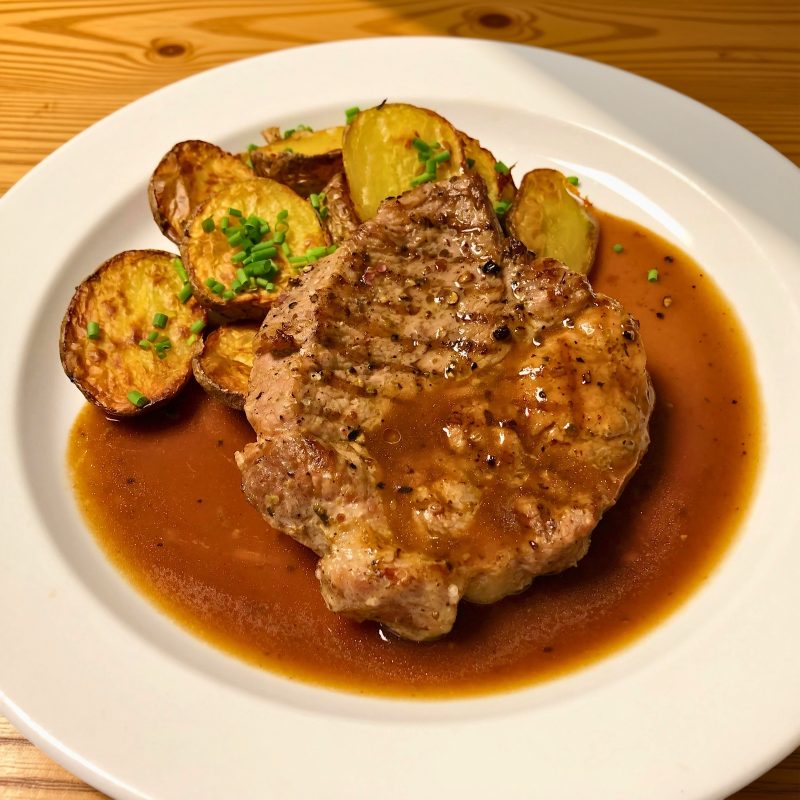 Grilovaný vepřový steak z krkovice, opečené grenaille sypané pažitkou