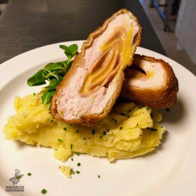 Smažená kuřecí kapsa plněná šunkou a čedarem, mačkané brambory sypané pažitkou