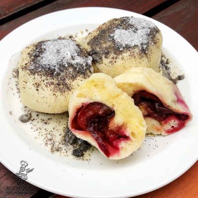 Kynuté švestkové knedlíky, sypané cukrem a mákem, přelité máslem
